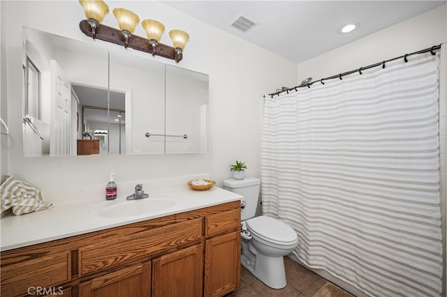 full bath featuring toilet, vanity, visible vents, and tile patterned floors