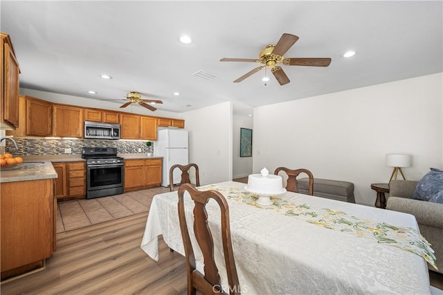 dining area with a ceiling fan, light wood-type flooring, visible vents, and recessed lighting