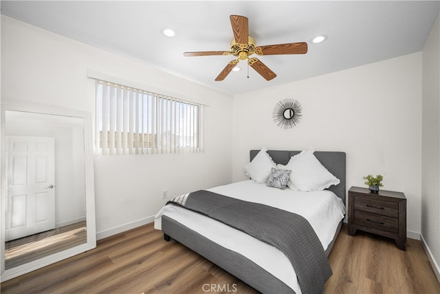 bedroom with recessed lighting, wood finished floors, and baseboards