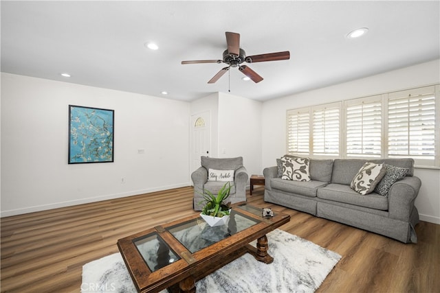 living area featuring baseboards, wood finished floors, and recessed lighting