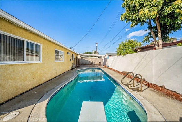 view of pool with a patio area, a fenced backyard, a diving board, and a fenced in pool