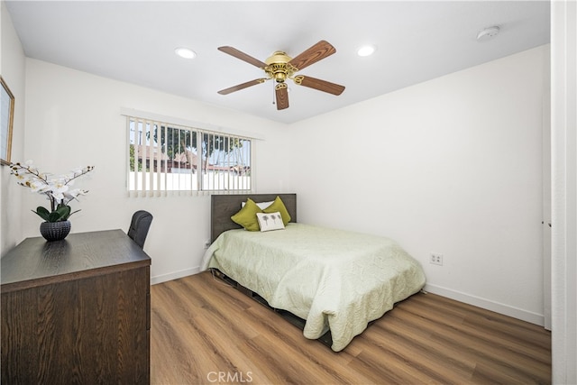 bedroom featuring a ceiling fan, baseboards, wood finished floors, and recessed lighting