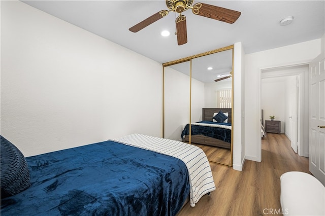 bedroom featuring baseboards, ceiling fan, wood finished floors, a closet, and recessed lighting