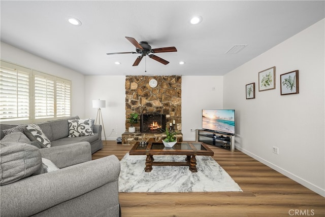 living room with a fireplace, wood finished floors, visible vents, and recessed lighting