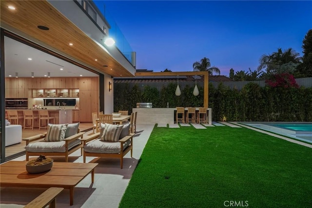 view of yard featuring a bar, fence, and an outdoor living space