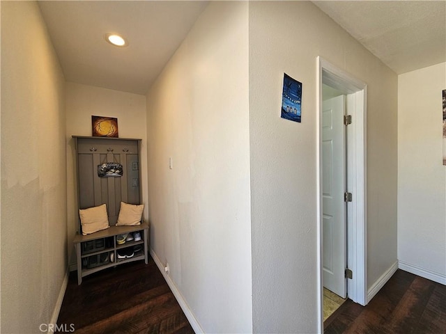 hallway with baseboards and dark wood-style flooring