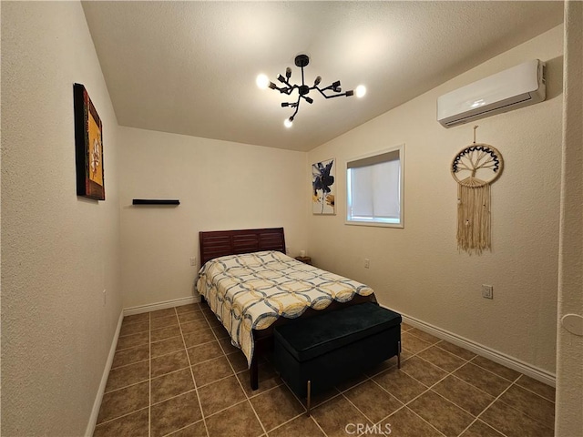 bedroom featuring baseboards, a textured wall, lofted ceiling, a wall mounted air conditioner, and dark tile patterned floors