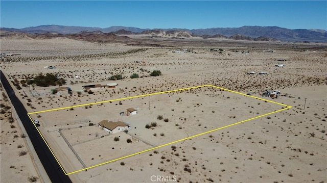 birds eye view of property featuring a mountain view and view of desert