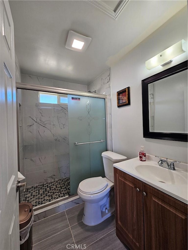 bathroom with toilet, vanity, and a marble finish shower