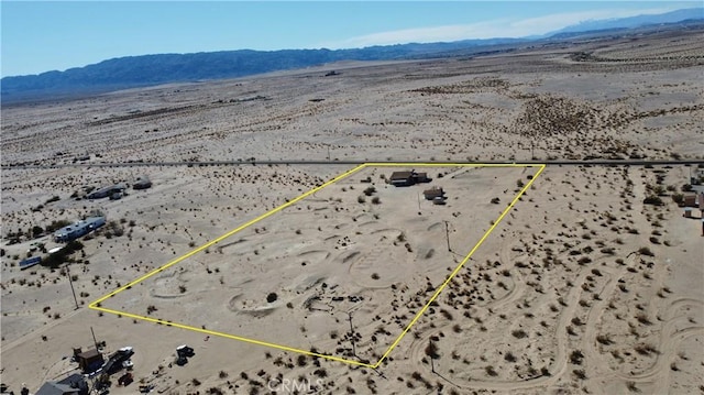 drone / aerial view featuring a mountain view and view of desert