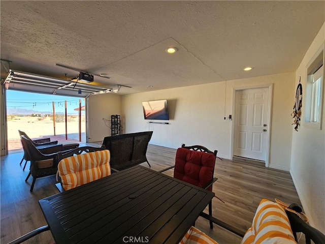 dining space featuring recessed lighting, a textured ceiling, baseboards, and wood finished floors