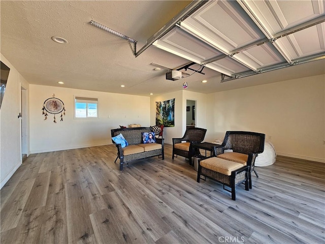 interior space featuring a garage, electric panel, light wood-style flooring, and baseboards