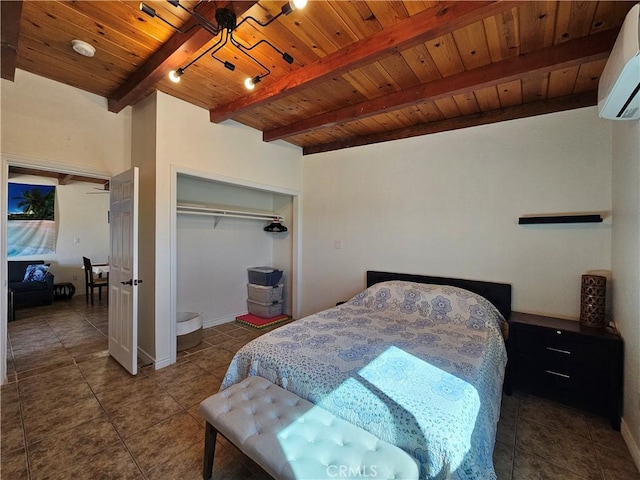 bedroom featuring dark tile patterned flooring, wood ceiling, a wall mounted AC, a closet, and beamed ceiling