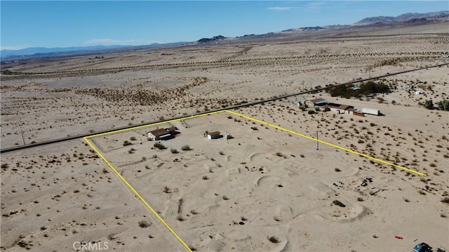 drone / aerial view featuring a mountain view and a desert view