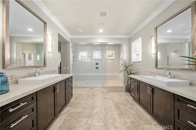 bathroom with crown molding, a stall shower, two vanities, and a sink