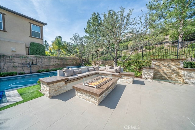 view of patio / terrace with an outdoor living space with a fire pit and a fenced backyard