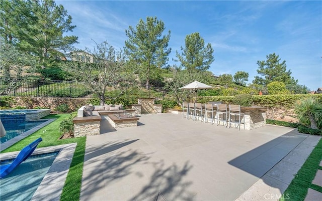 view of patio / terrace with a fenced in pool, outdoor dry bar, an in ground hot tub, fence, and outdoor lounge area