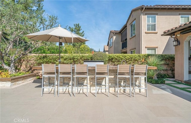 view of patio / terrace featuring exterior bar and fence