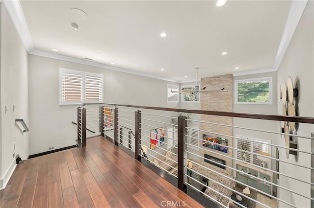 corridor featuring ornamental molding, recessed lighting, baseboards, and wood finished floors