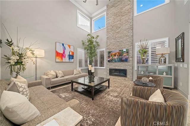 living room with baseboards, a fireplace, and a high ceiling