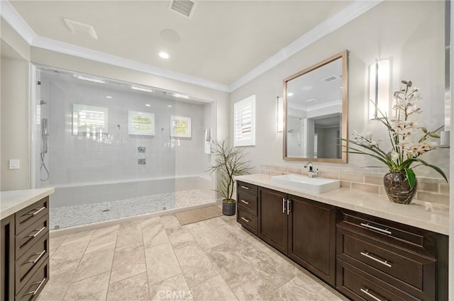 full bathroom featuring vanity, walk in shower, visible vents, and crown molding