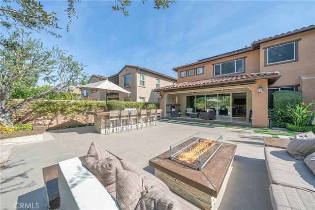 view of patio / terrace featuring outdoor dry bar and an outdoor living space with a fire pit