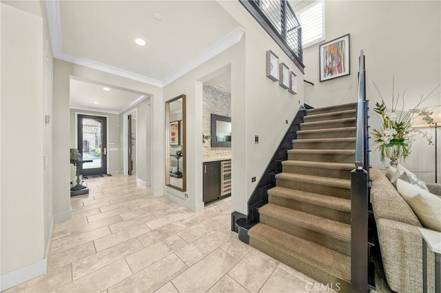 stairs with baseboards, ornamental molding, and recessed lighting