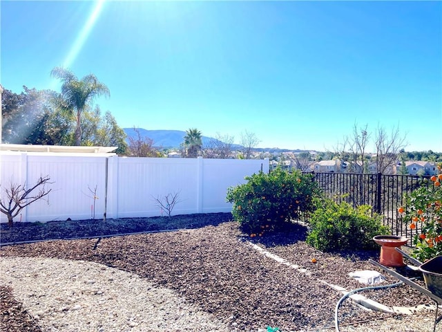 view of yard featuring a fenced backyard and a mountain view