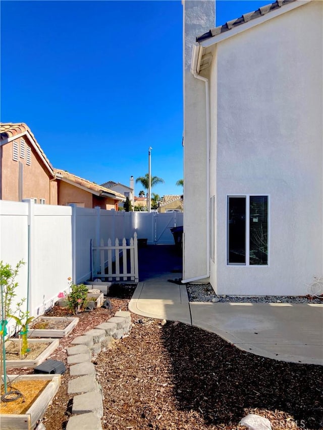 view of yard featuring a patio area, fence, and a garden