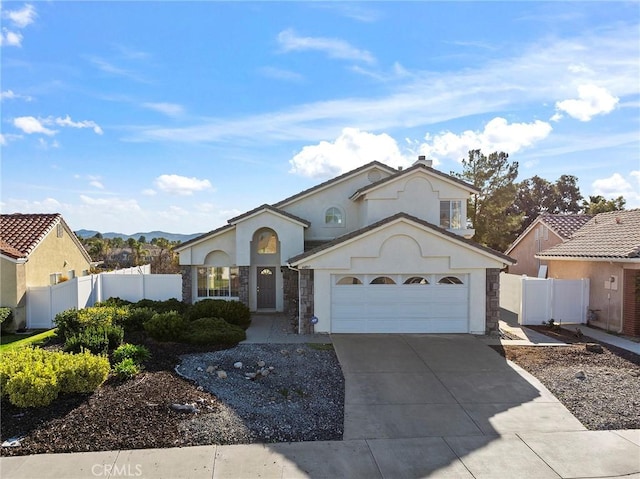 view of front of property featuring driveway, an attached garage, fence, and stucco siding