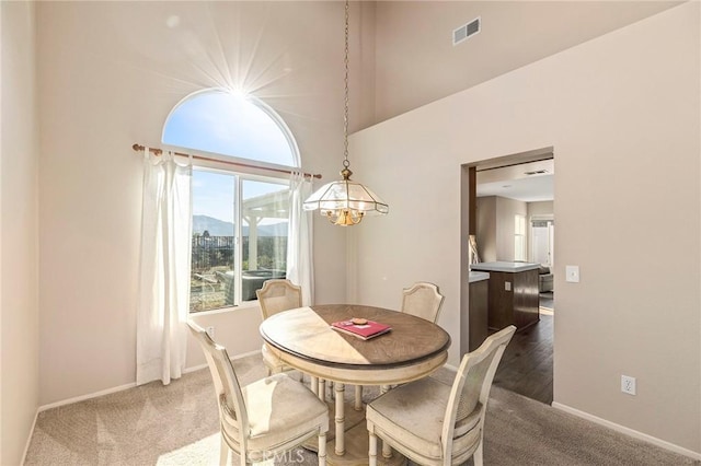 dining space with baseboards, visible vents, and dark colored carpet