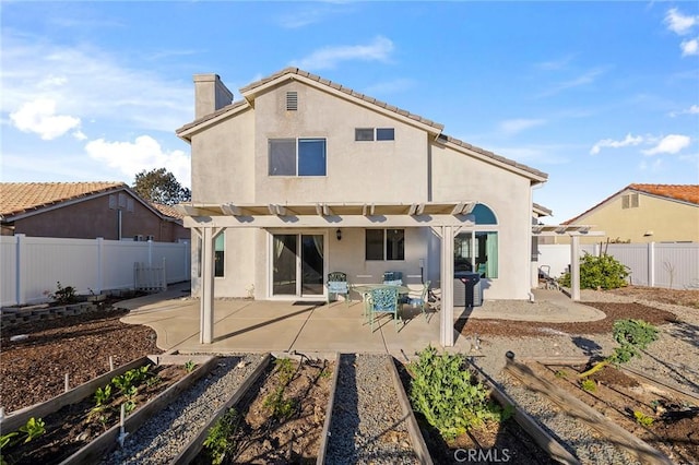 back of property featuring a patio, stucco siding, a fenced backyard, a pergola, and a garden