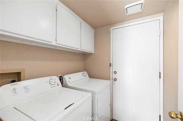 laundry room featuring washing machine and dryer, cabinet space, and visible vents