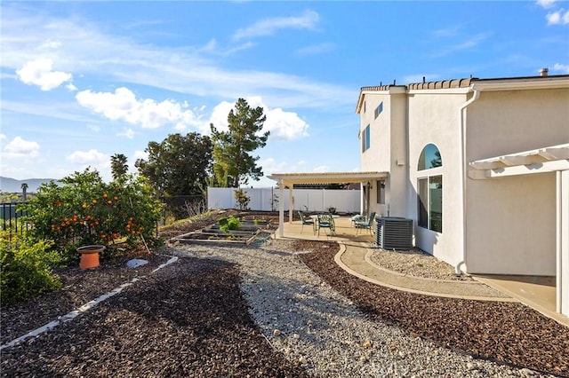 view of yard featuring a fenced backyard, a patio, and central AC unit