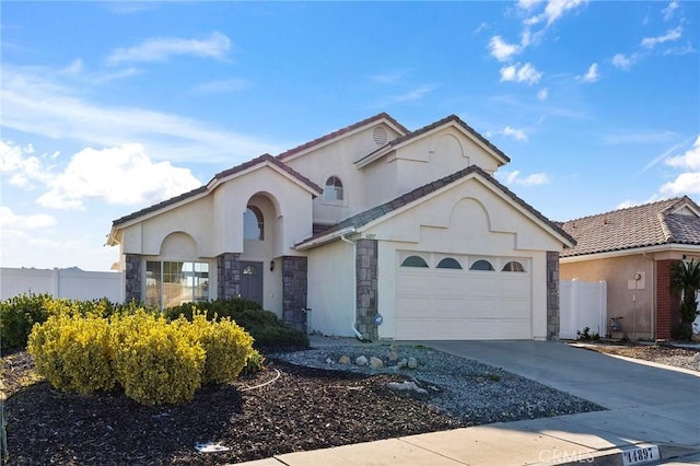 mediterranean / spanish home with driveway, stone siding, an attached garage, fence, and stucco siding