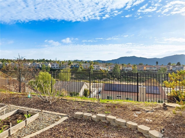 view of yard with a residential view, a garden, a mountain view, and fence