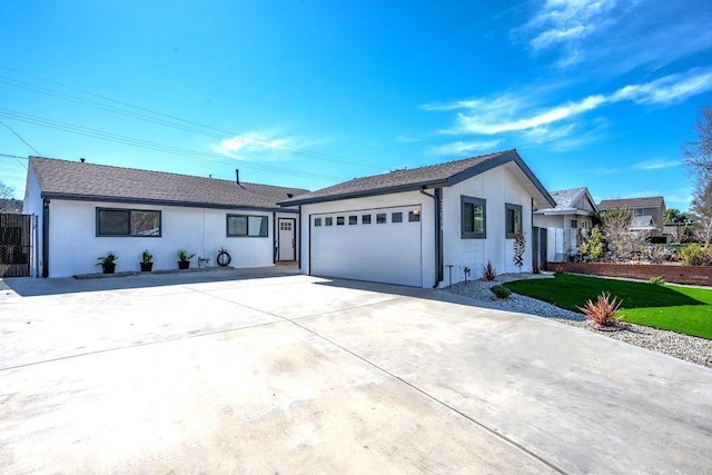 ranch-style house featuring a garage, driveway, and stucco siding