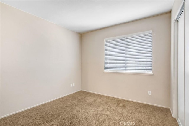 carpeted spare room with baseboards