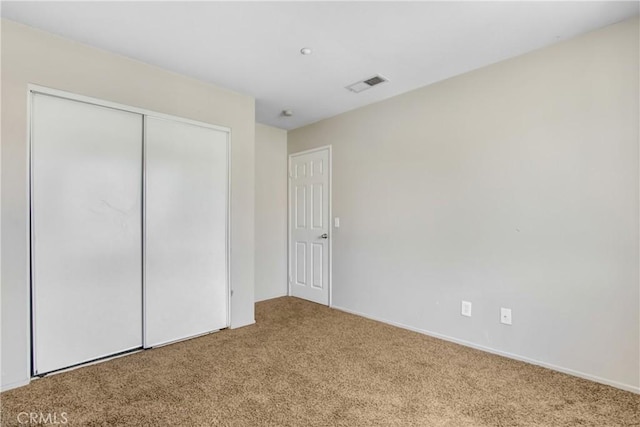 unfurnished bedroom featuring carpet floors, a closet, and visible vents