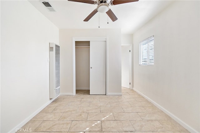 unfurnished bedroom with a heating unit, a closet, visible vents, and baseboards