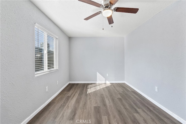 unfurnished room with a textured wall, a ceiling fan, a textured ceiling, wood finished floors, and baseboards