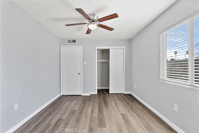 unfurnished bedroom featuring a textured ceiling, visible vents, and baseboards