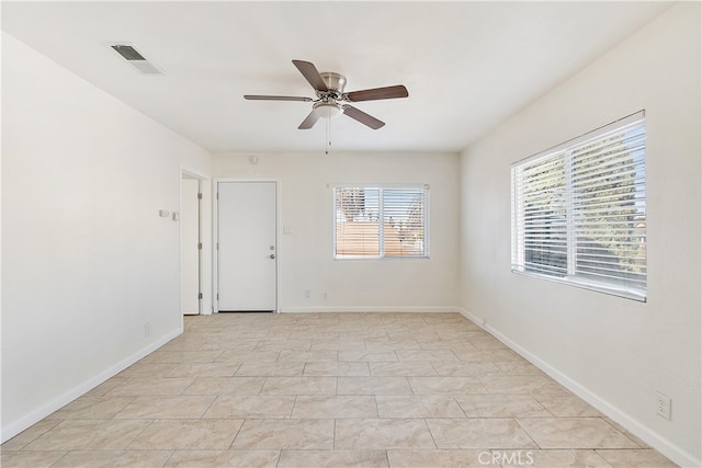 unfurnished room with visible vents, ceiling fan, and baseboards