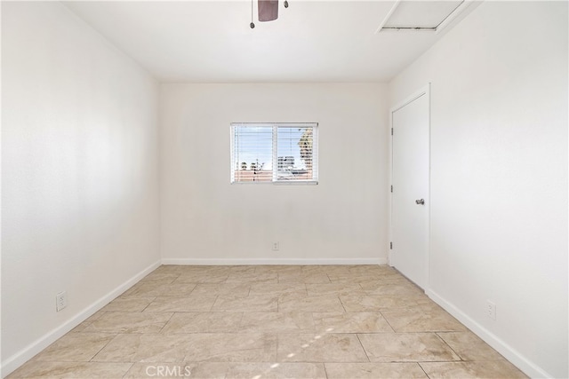 empty room featuring ceiling fan and baseboards