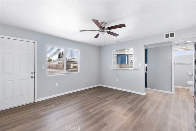 entryway with a ceiling fan, wood finished floors, visible vents, and baseboards