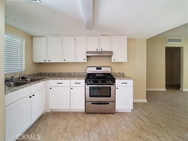 kitchen featuring visible vents, white cabinets, a sink, gas range, and under cabinet range hood