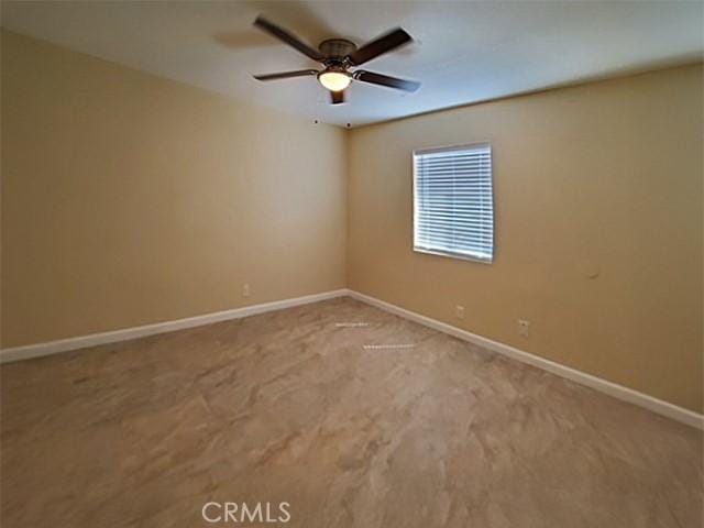 unfurnished room featuring carpet flooring, ceiling fan, and baseboards