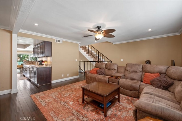 living area with dark wood-style floors, ornamental molding, visible vents, and baseboards