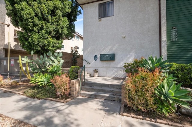 view of side of property featuring fence and stucco siding