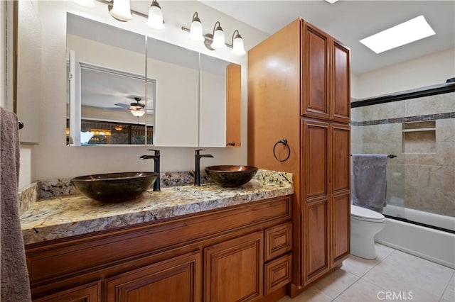 bathroom with combined bath / shower with glass door, tile patterned flooring, a sink, and toilet